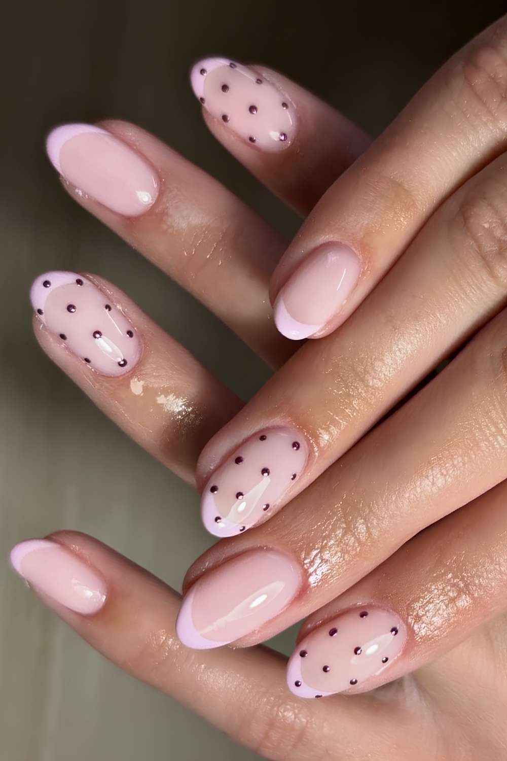Milky pink nails with accent metallic polka dots