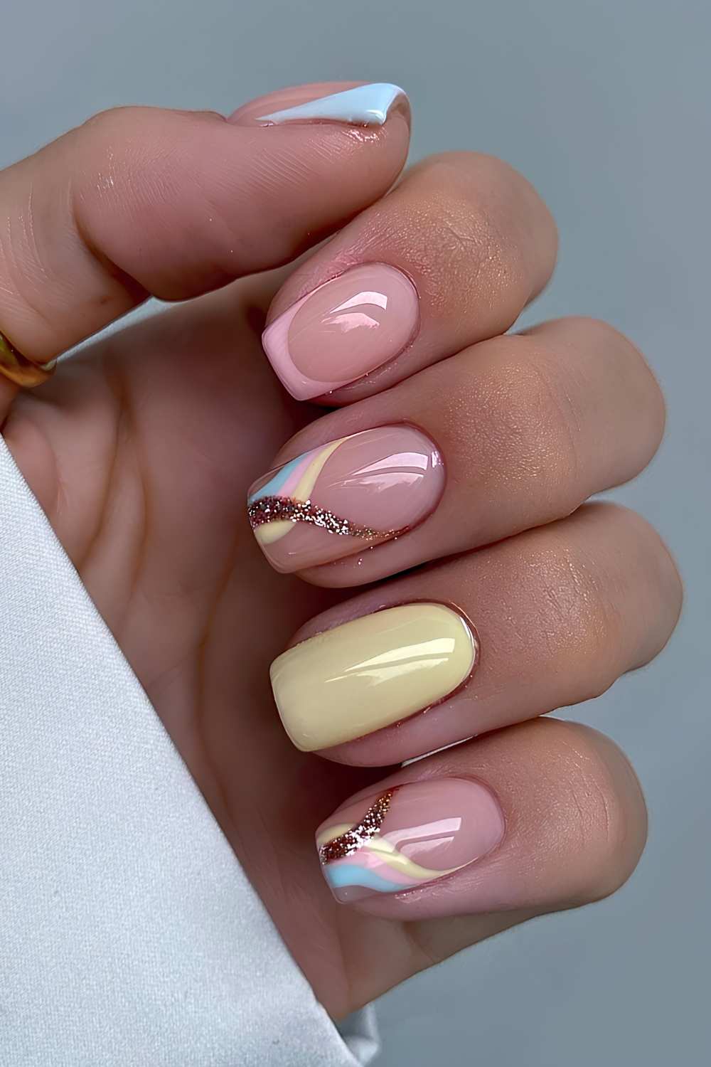 Pink and yellow mani with swirls and gold glitter