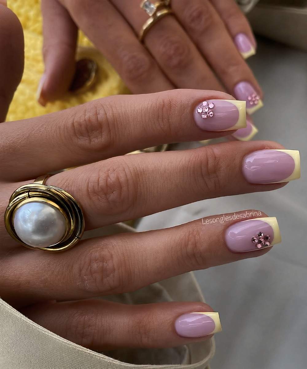 Yellow French nails with pink gem flowers