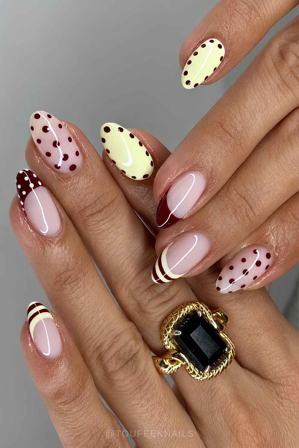 Burgundy and pastel yellow nails with dots and stripes