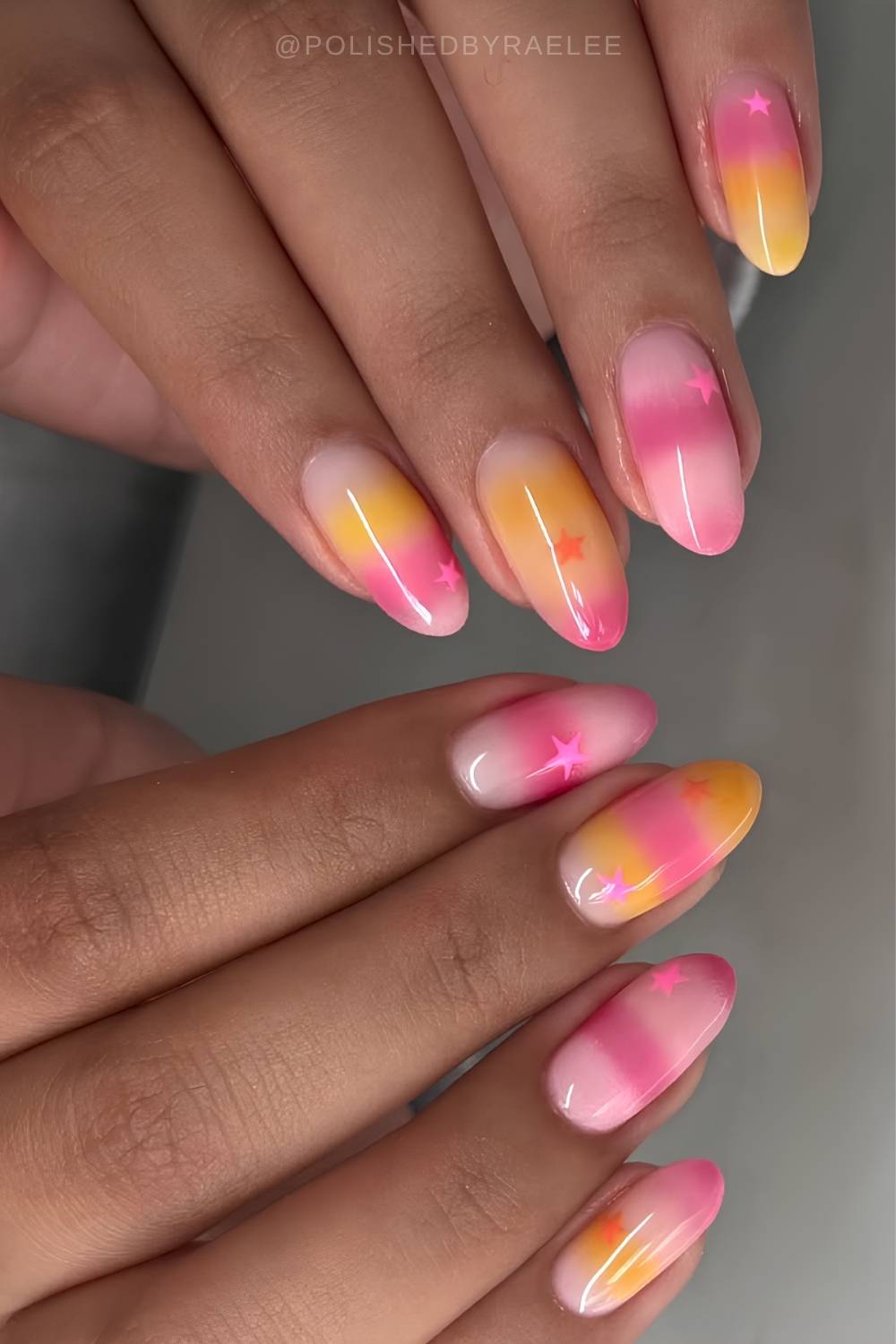 Pink and yellow nails with stripes and stars