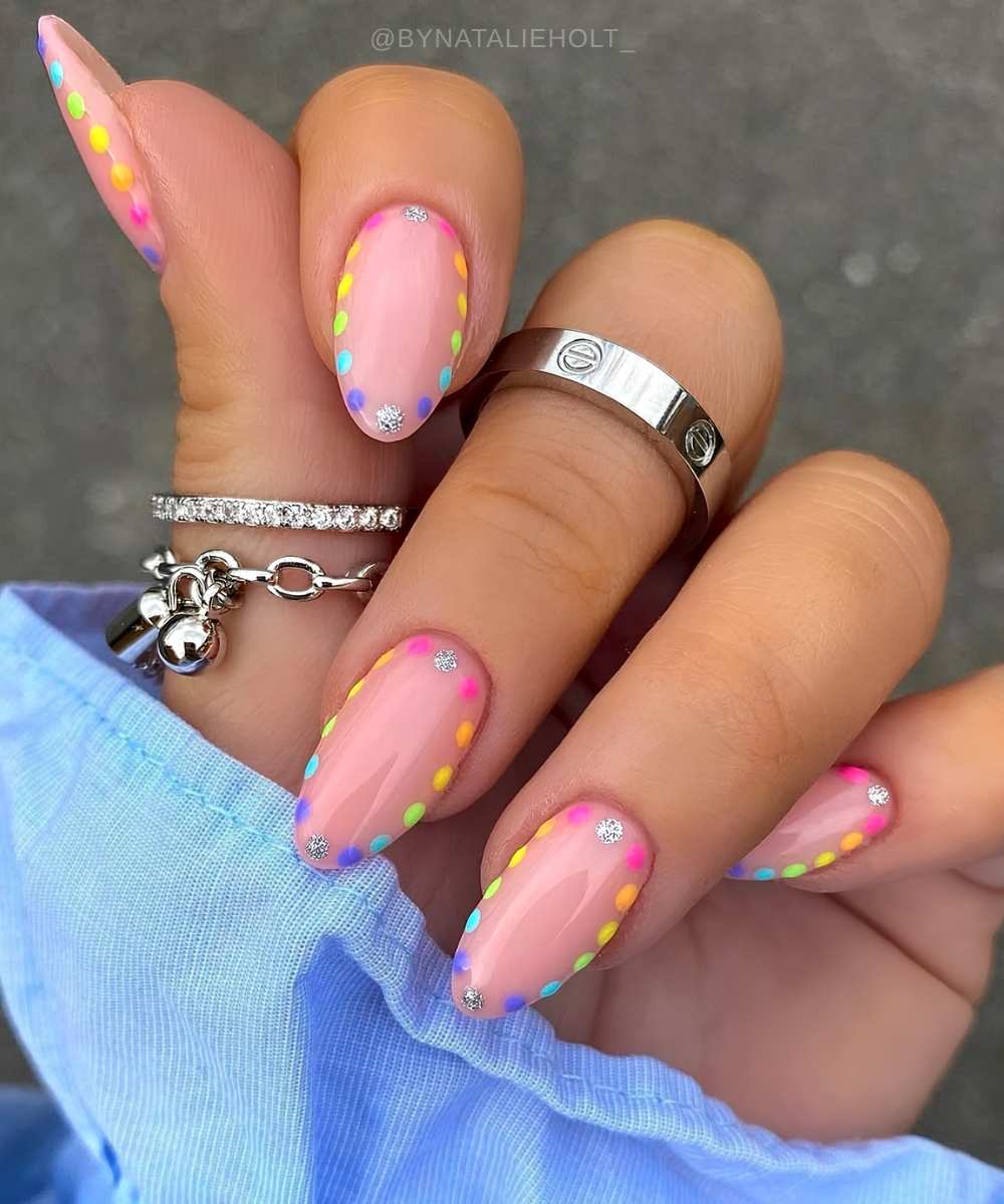 Pink nails with rainbow polka dot outlines