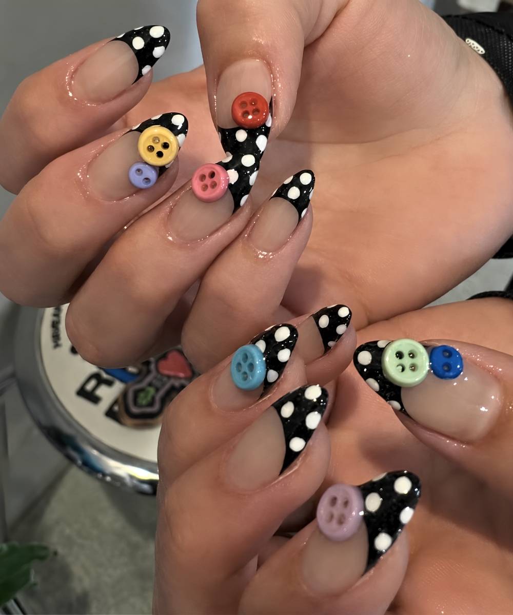 Black polka dot French nails with colorful buttons