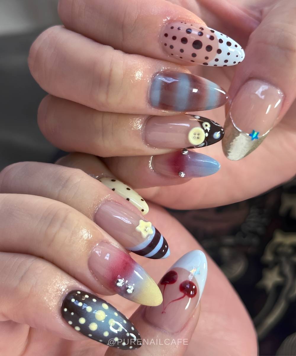 Mismatched nails with buttons and stripes in muted colors