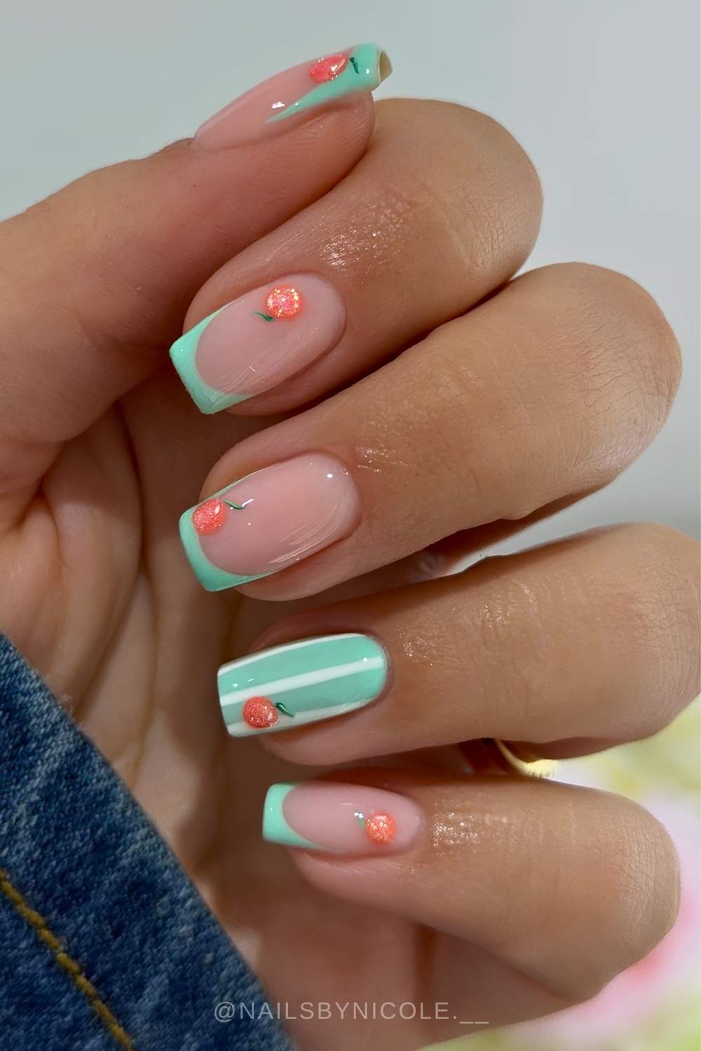 Pastel green nails with stripes and orange fruit