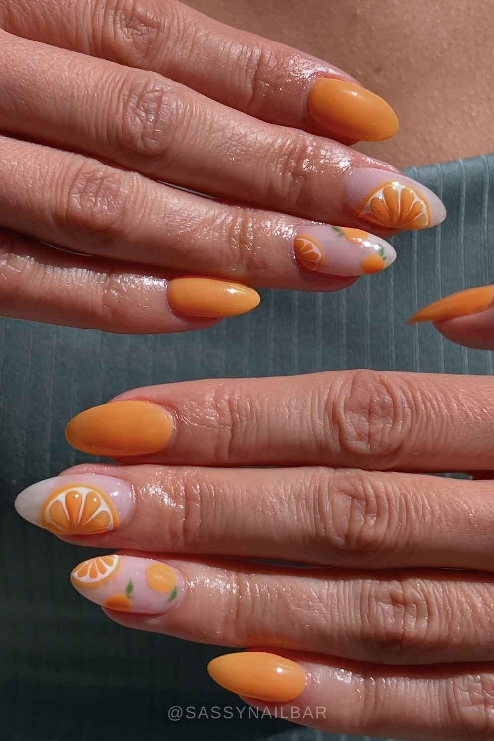 Pastel orange nails with citrus slice accents