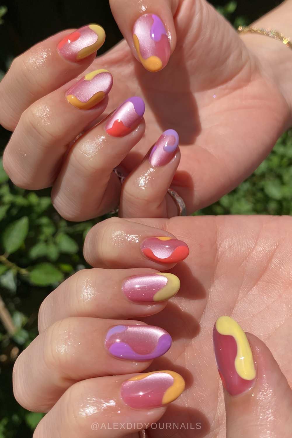 Pink cat eye nails with colorful accent swirls