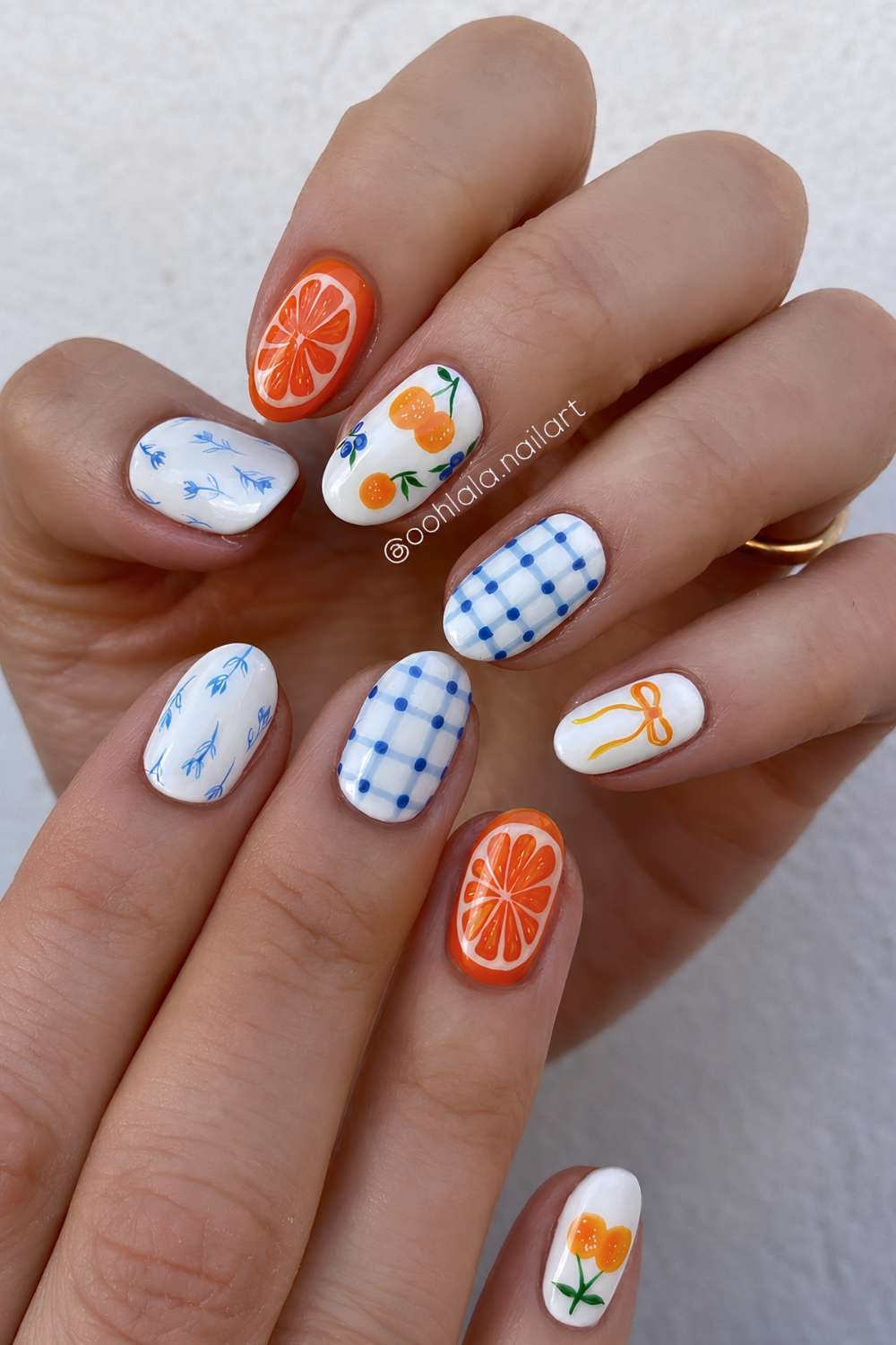 White nails with orange fruit and blue gingham