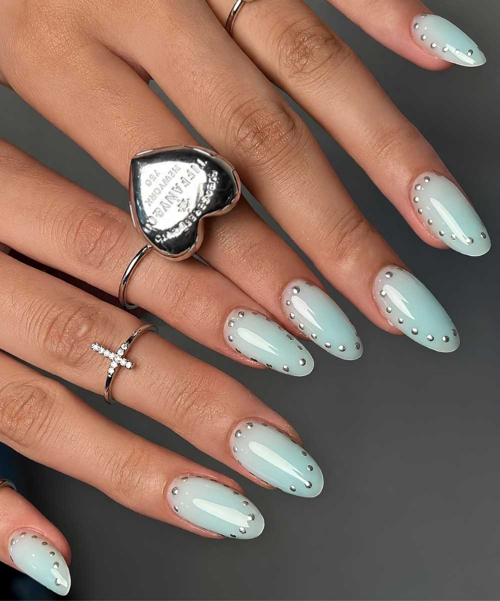 Light teal nails with dotted silver outlines