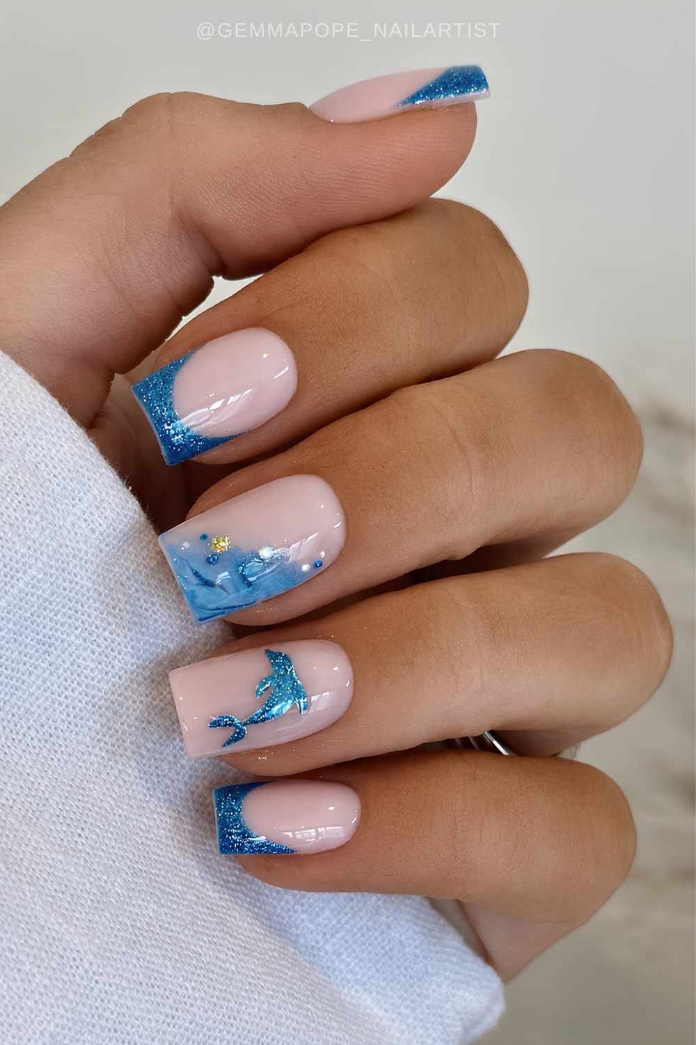 Shimmery blue French mani with ocean motifs