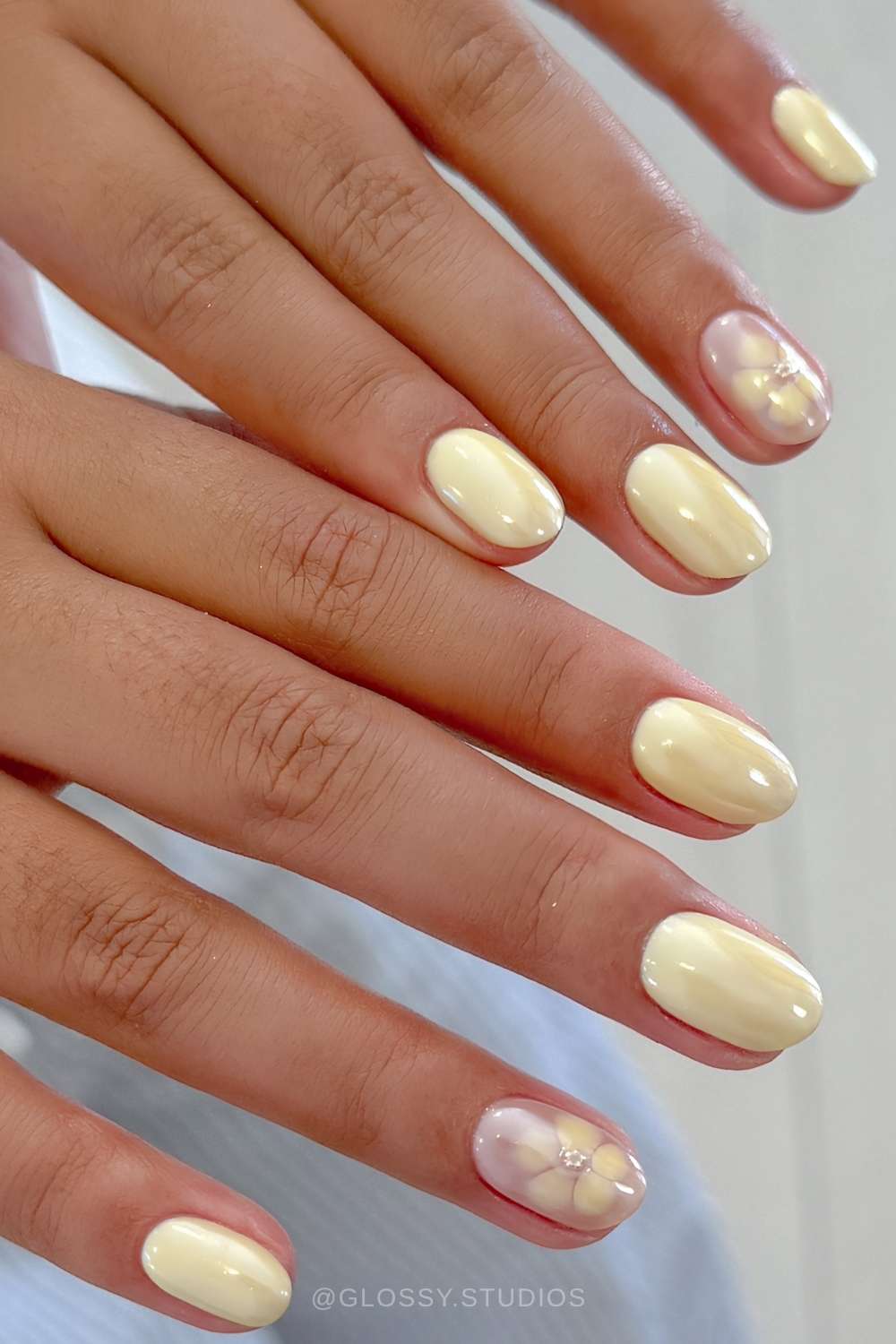 Short butter yellow chrome nails with blooming gel flowers