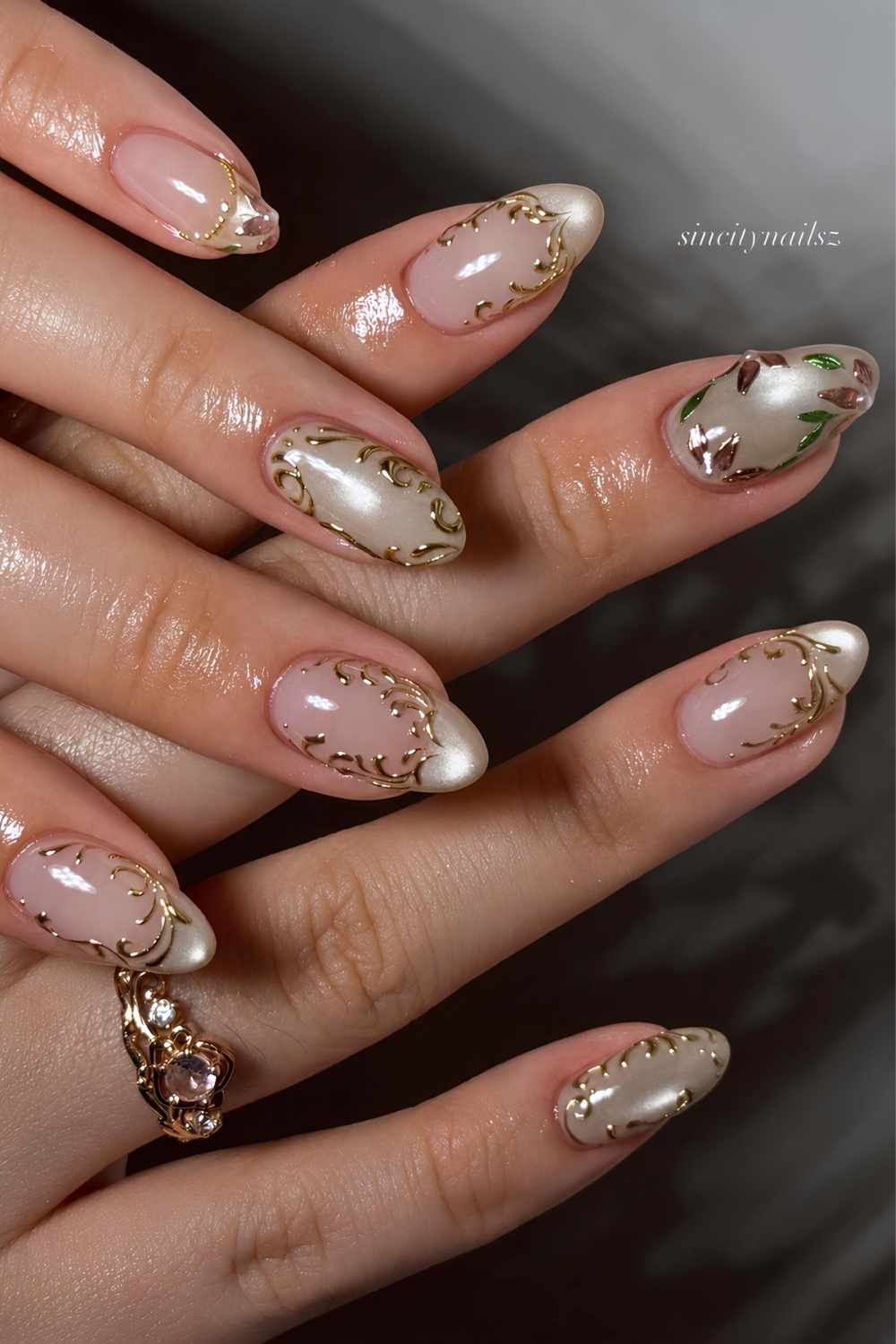 Soft green cat eye nails with flowers and gold swirls