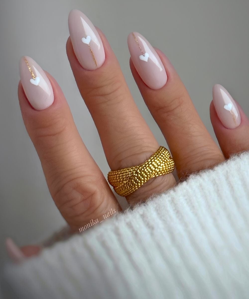 Beige nails with white hearts and glitter