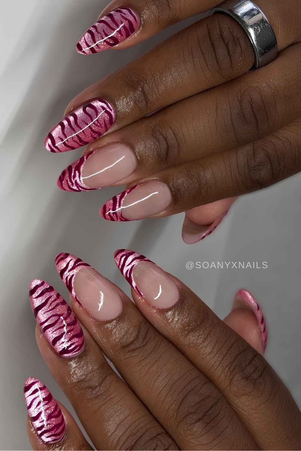 Bright pink cat eye nails with zebra stripes
