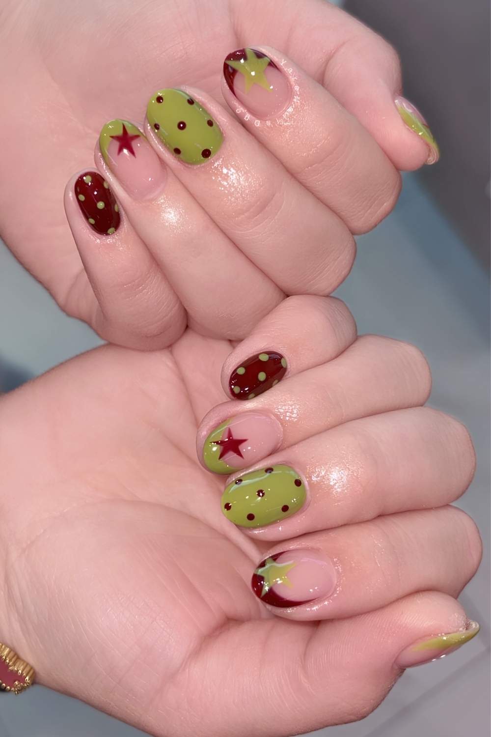 Burgundy and green nails with stars and polka dots