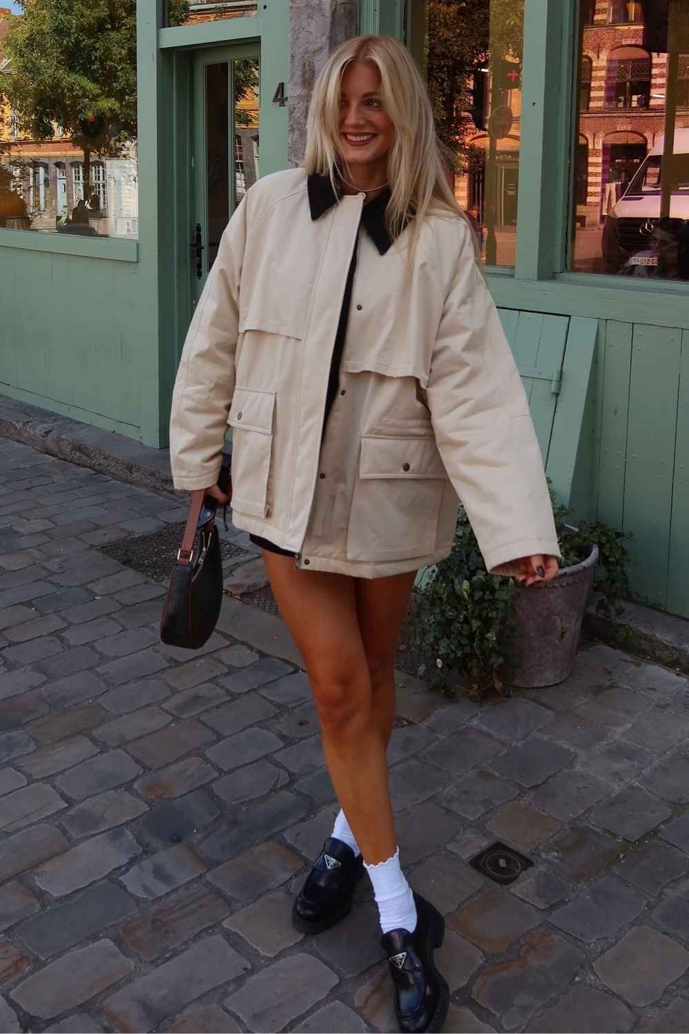 Cream barn jacket with black loafers and white socks