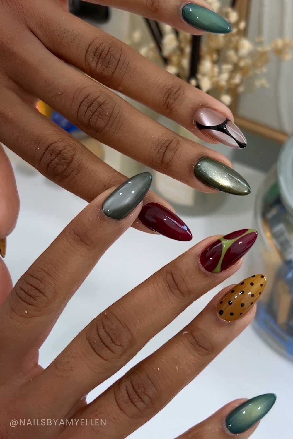 Green and burgundy cat eye mani with lines and dots
